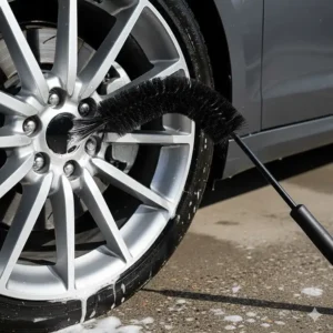 Using a long-reach flexible brush to clean rims by reaching the inner barrel behind the spokes.