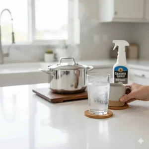 Placing a coaster under a glass or a hot pad under a pot to illustrate best practices for protecting granite and quartz surfaces from damage.