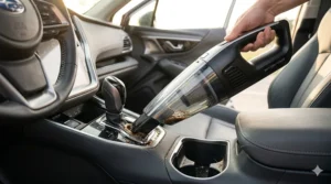A handheld car vacuum cleaner effectively suctioning spilled coffee from a center console cup holder.