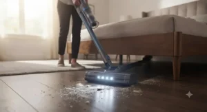 Woman using a sleek vacuum with LED headlights to clean bedroom flooring under a bed
