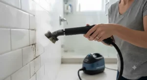 Using a canister steam cleaner brush attachment to remove grime from tiled bathroom grout lines.