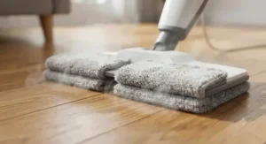Close-up of an electric steam mop for hardwood floors featuring dual microfiber cleaning pads.