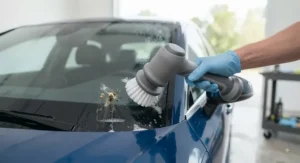 A compact power scrubber cleaning hard-to-reach areas on a vehicle windshield and exterior glass.